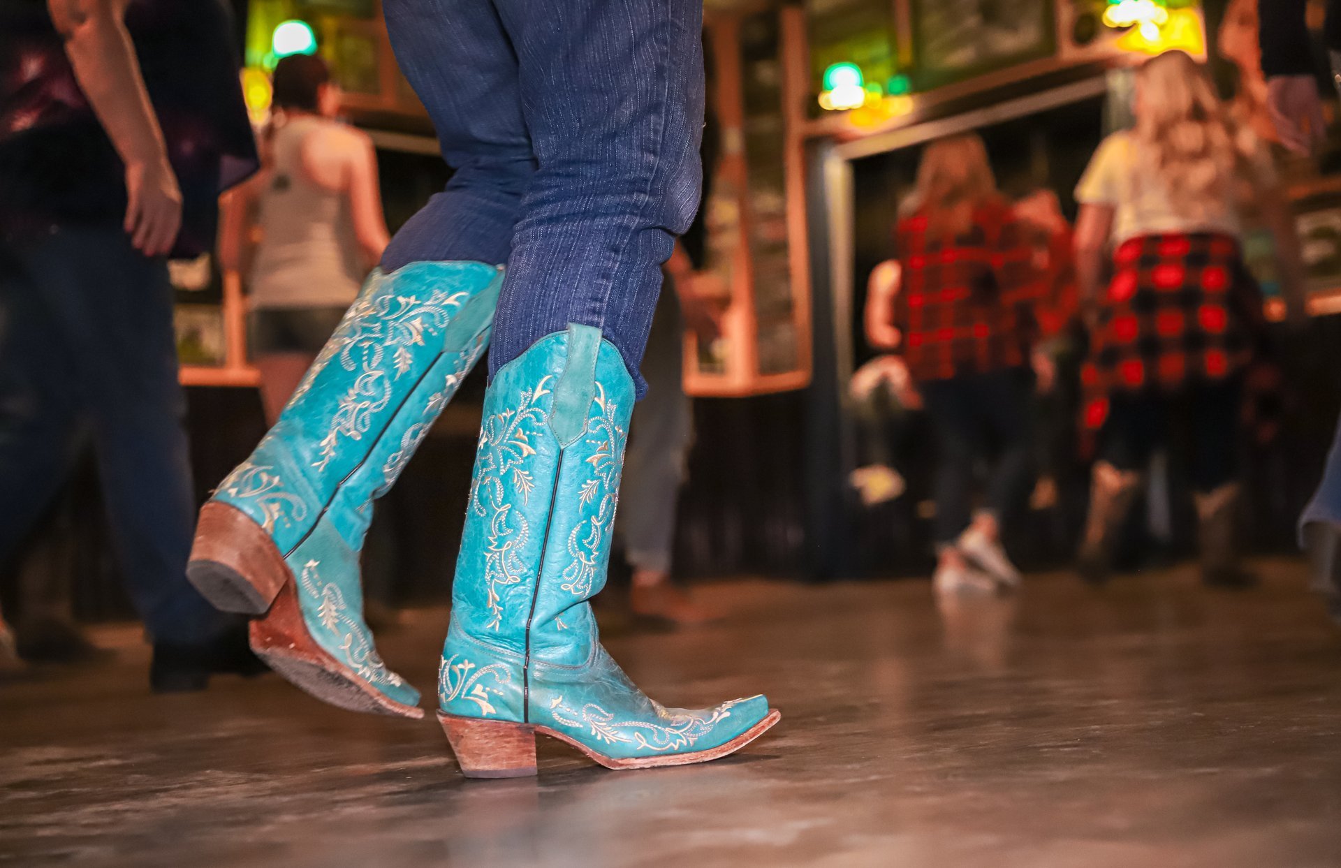 Las Vegas, United States – January 01, 2020: Las Vegas, Nevada - January 2020: A female wearing turqoise cowboy boots dances at a bar's country-themed night.