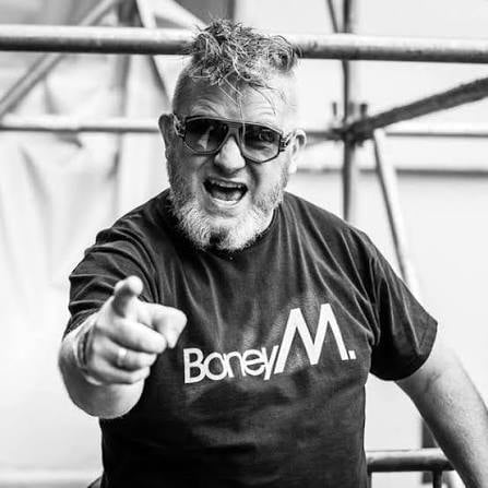 Bearded man wearing sunglasses and Borell M t-shirt pointing at camera