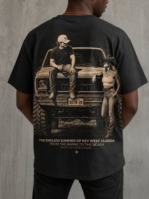 Man wearing black t-shirt with vintage-style graphic of two people on a rugged jeep and Key West text on back